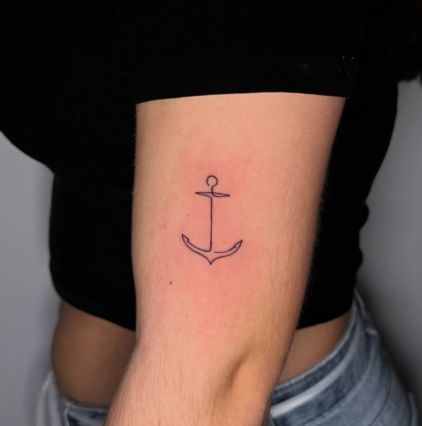 Tatuaje minimalista de ancla en línea fina