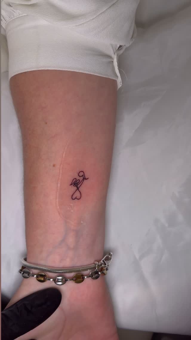 Tatuaje fine line de manos formando un corazón