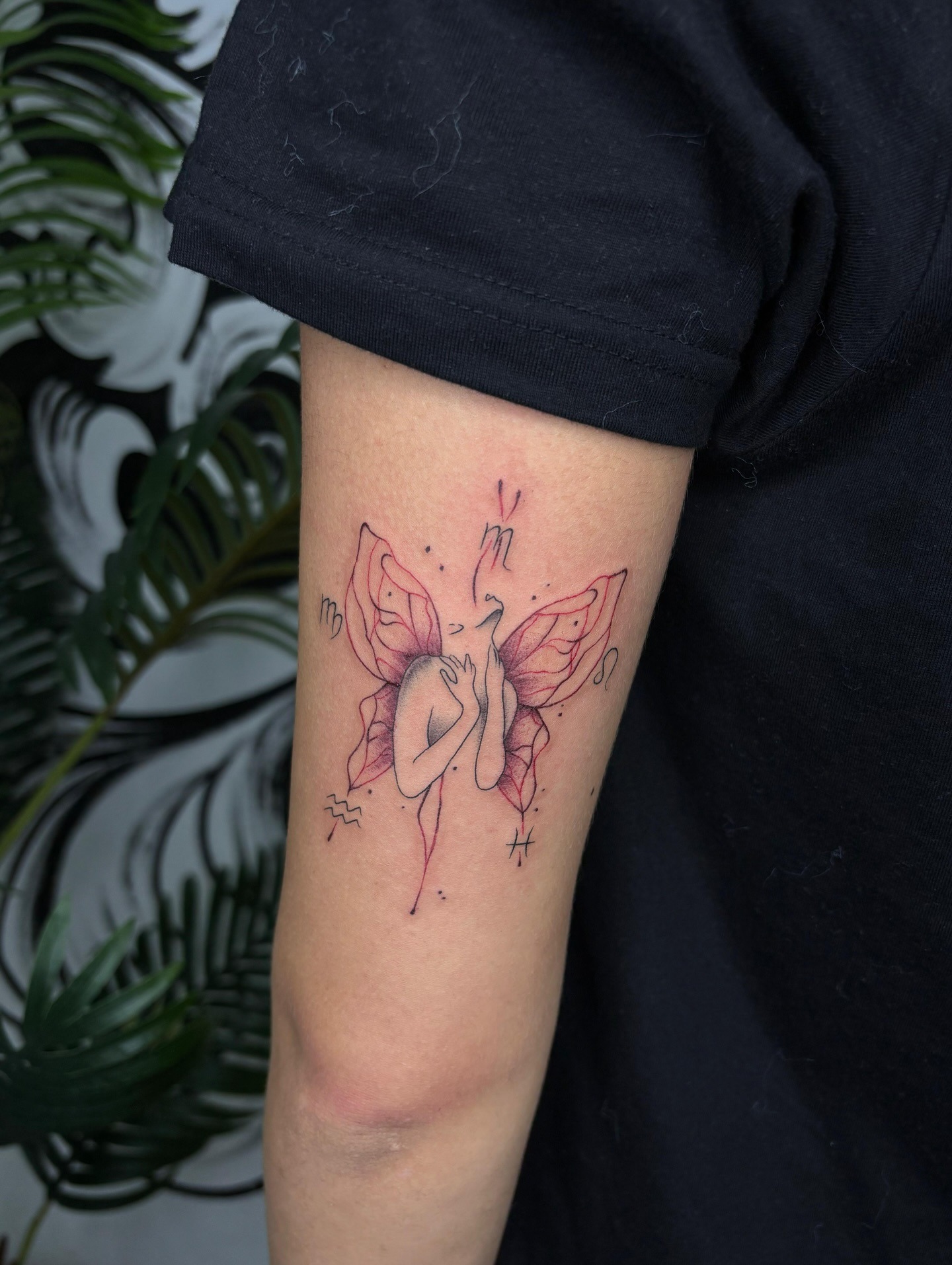Tatuaje de figura femenina con alas de mariposa y trazos rojos